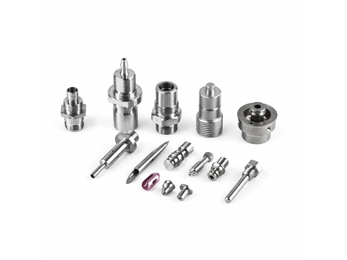 Custom CNC turning services for small precision metal components fittings pins and adapters on a pure white background