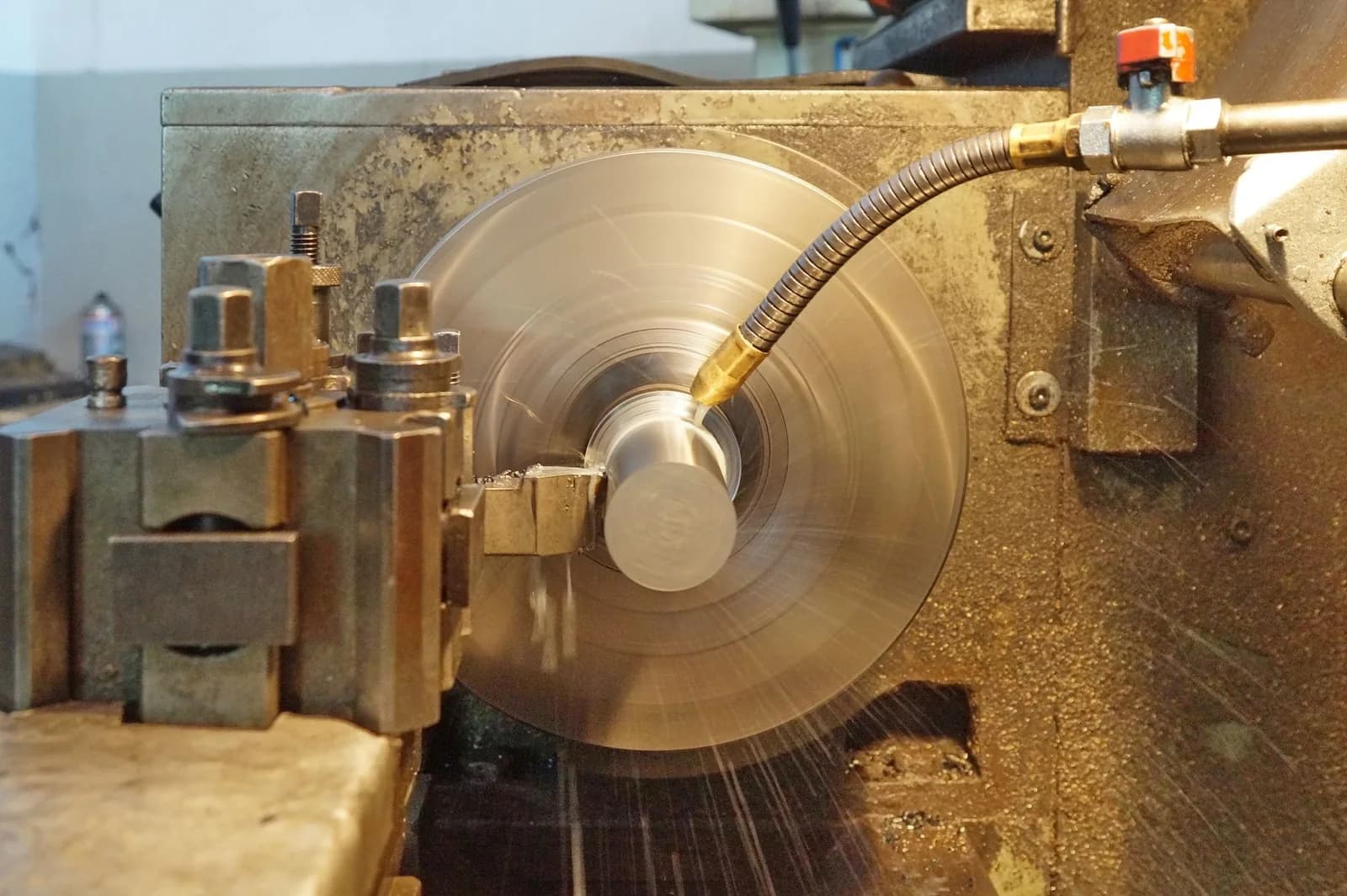 Steel workpiece rotating while a lathe tool performs a CNC turning cut