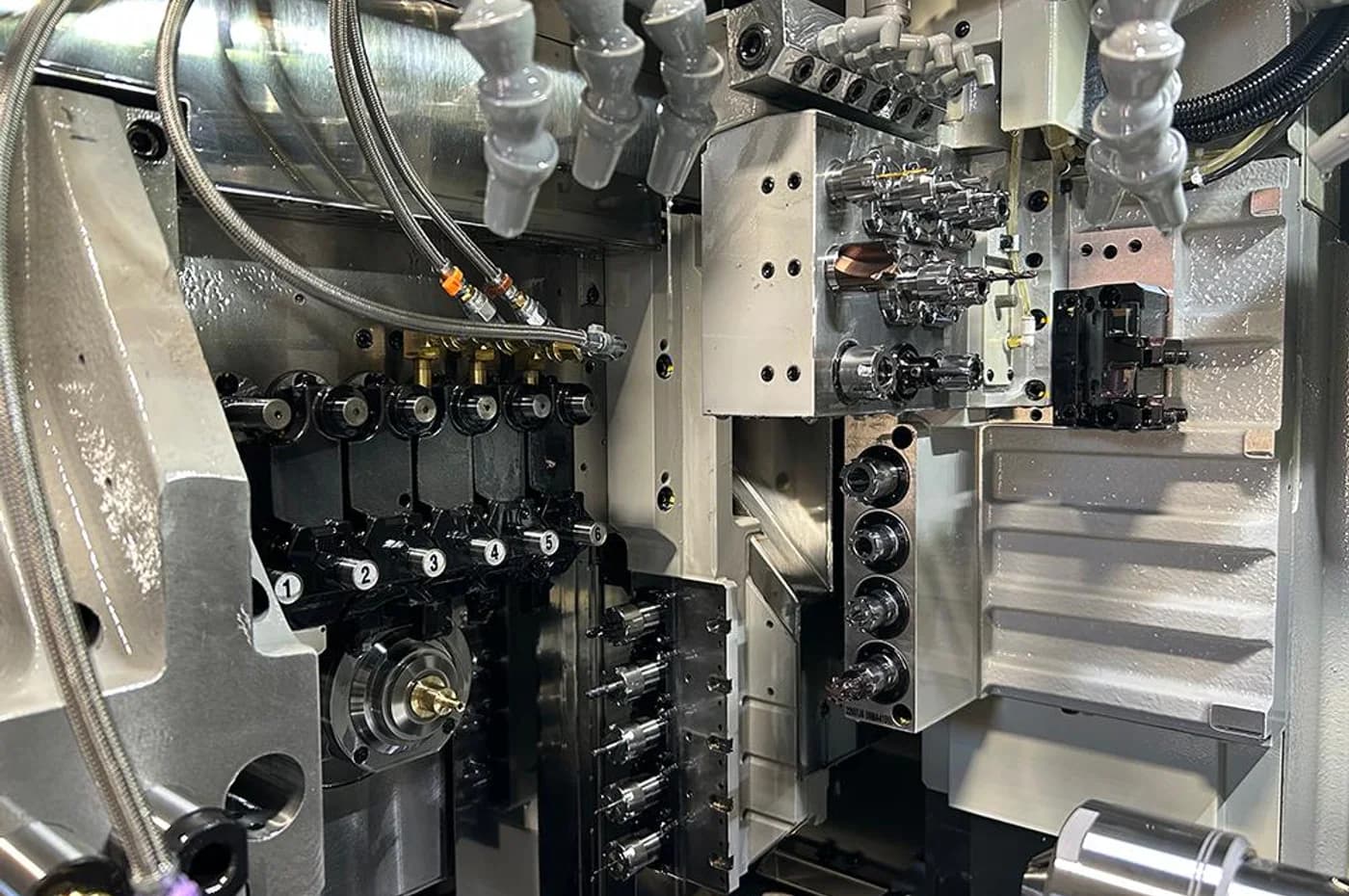 Multi-axis Swiss-type lathe machining area with opposing spindles and multiple tool stations