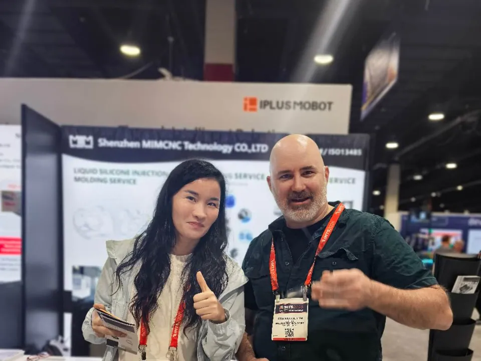 MIM Machining representative meeting an IMTS Chicago attendee at the CNC machining booth