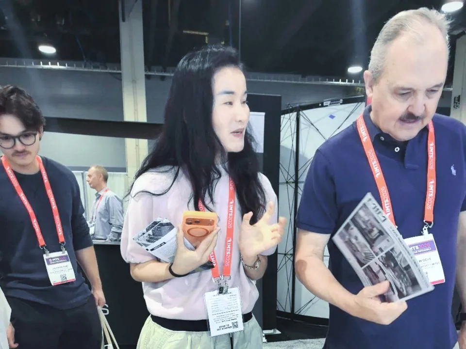 CNC machining brochure and component discussion at the IMTS booth