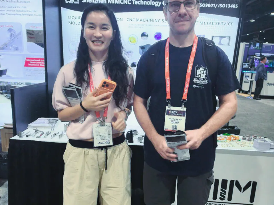 CNC machining customer conversation at the MIM Machining IMTS exhibition booth