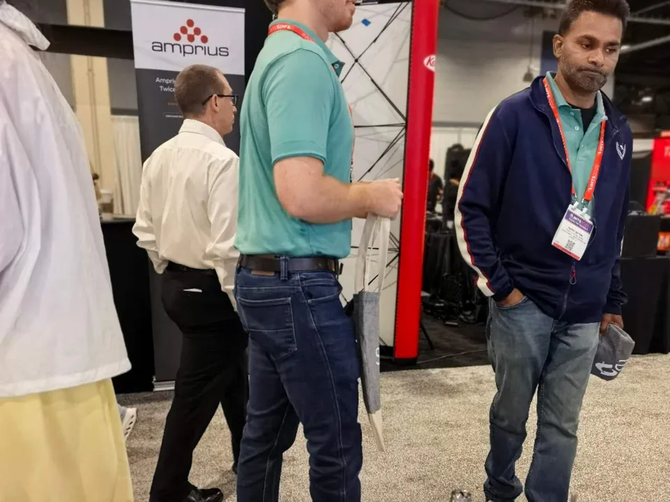 Engineers discussing precision machined parts and manufacturing requirements at IMTS Chicago