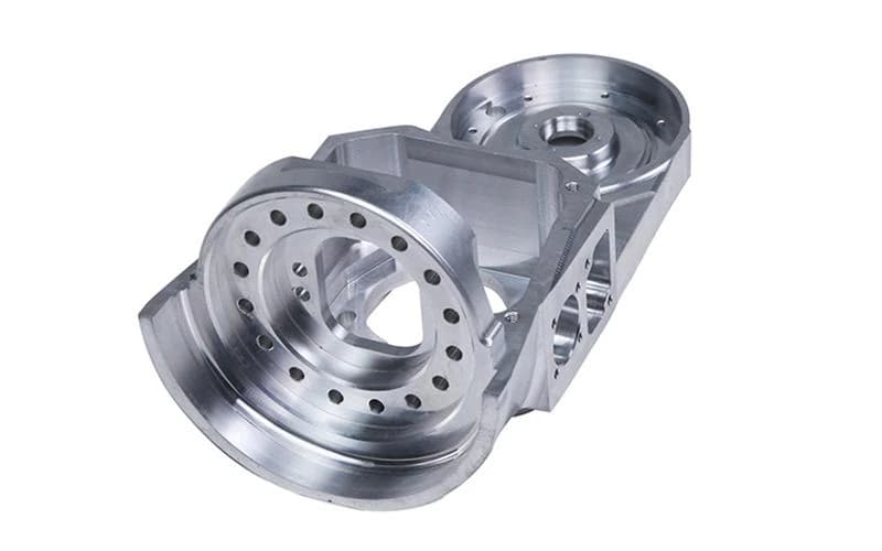 Complex five-axis CNC machined aluminum bearing housing with intersecting bores on a white background