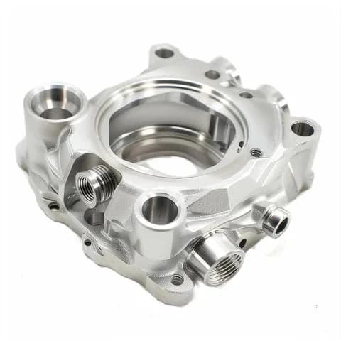 Complex CNC machined aluminum multi-port housing with threaded openings on a white background