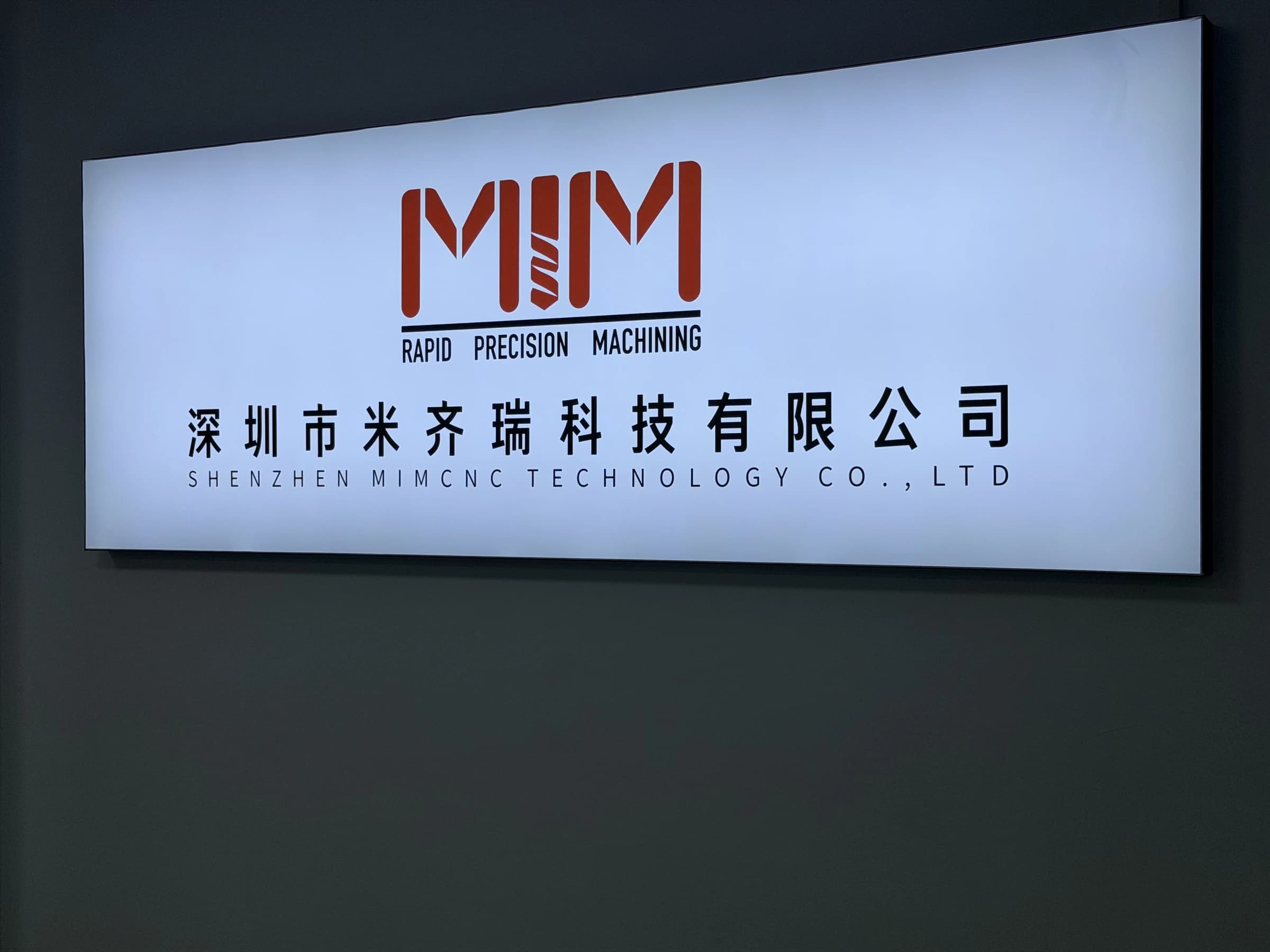 Complete MIM company sign showing the red MIM logo, Shenzhen MIMCNC Technology Co., Ltd. in Chinese and the English legal company name