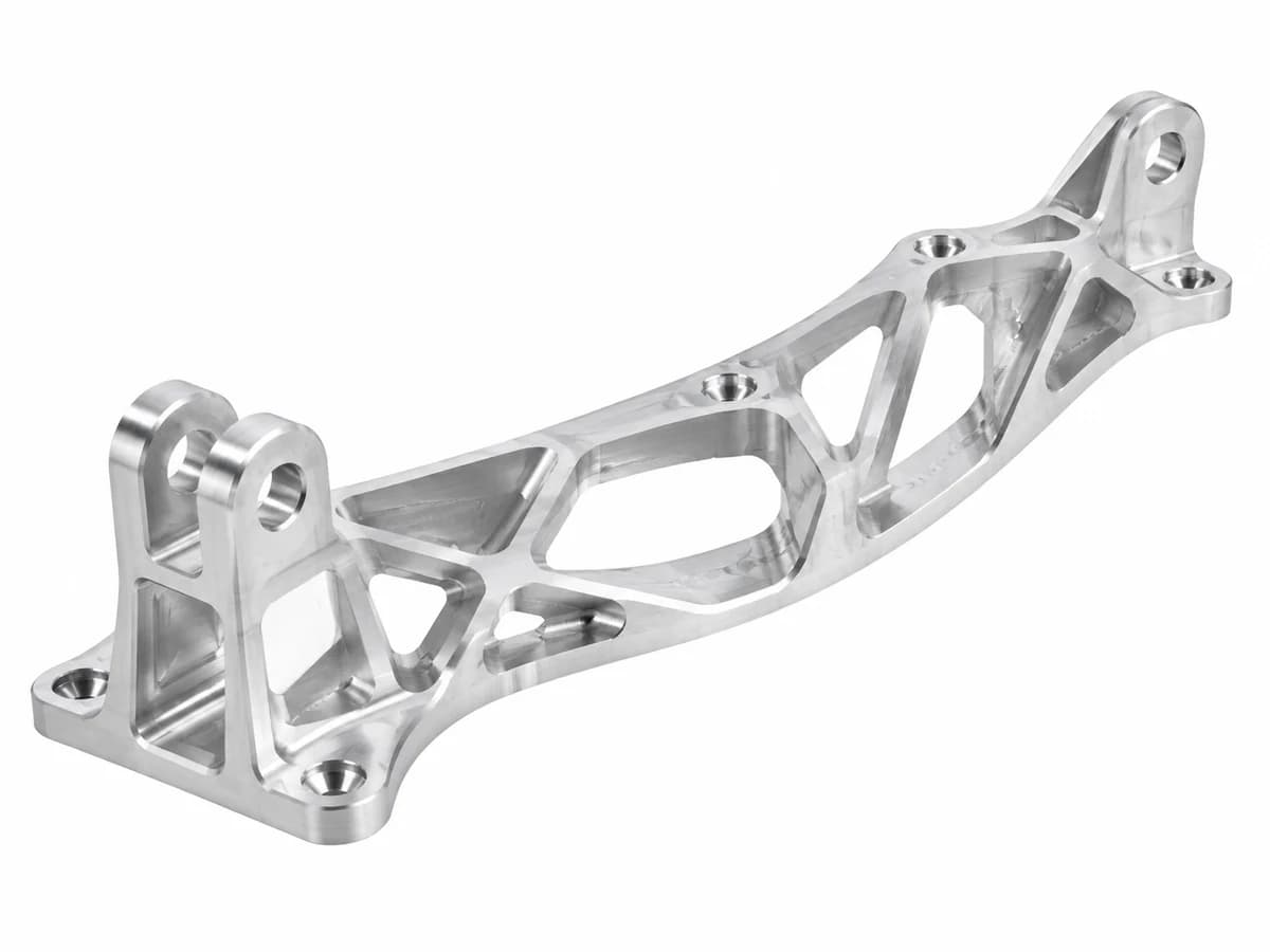 Thin-wall CNC machined aluminum structural bracket with pockets ribs and mounting lugs on a pure white background