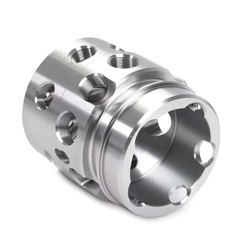 Complex CNC machined silver valve body with radial threaded ports and internal bore on a pure white background