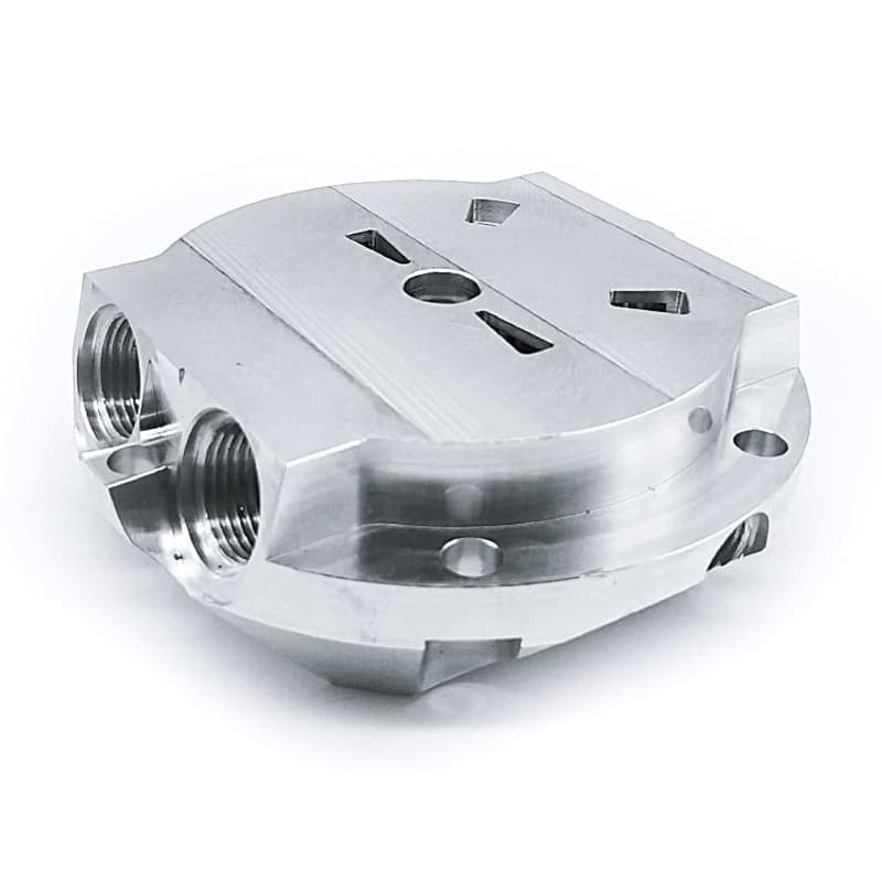 Custom CNC milled silver enclosure with threaded ports slots and machined faces on a pure white background