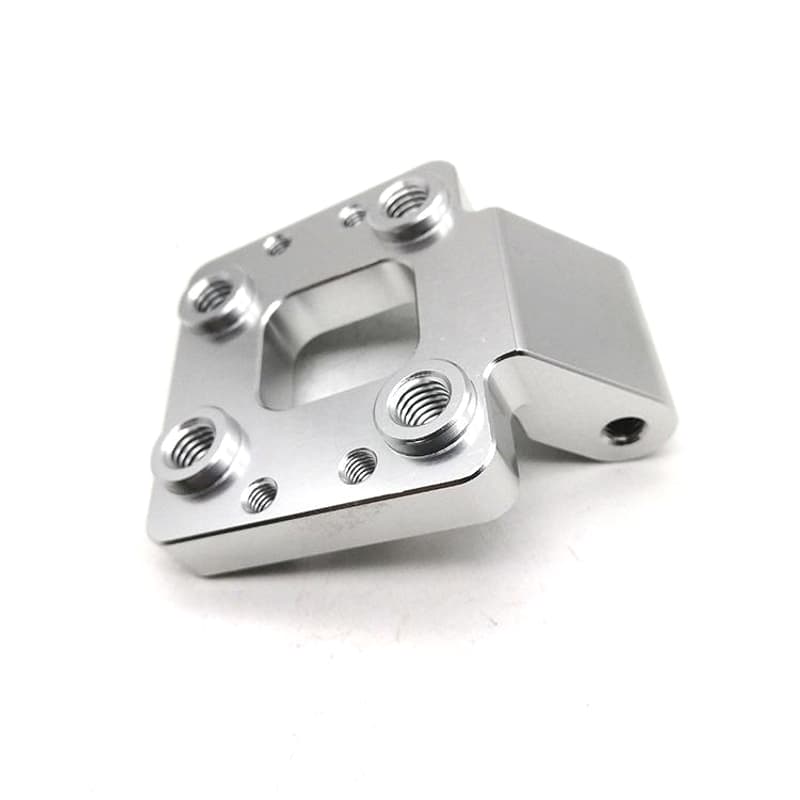 Custom CNC milled silver mounting bracket with threaded bosses pocket and locating holes on a pure white background