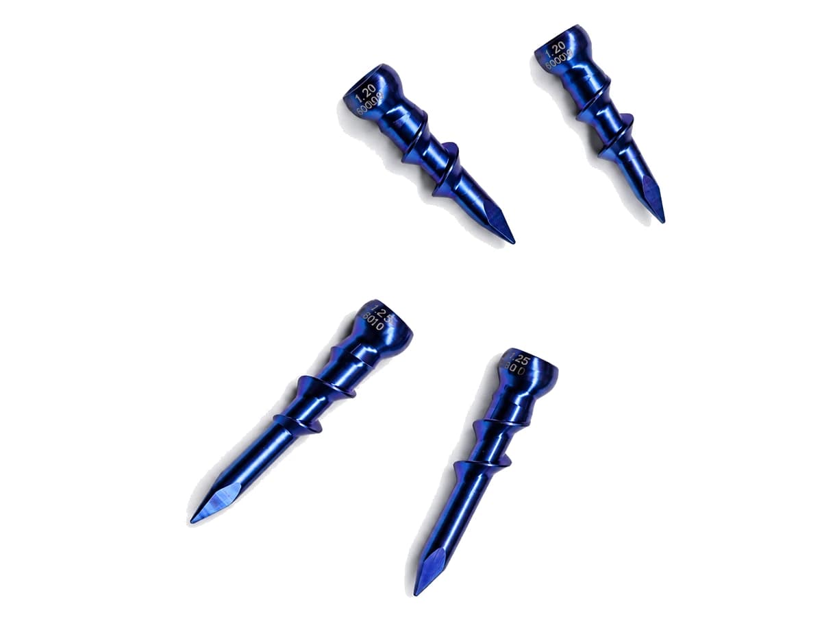 Four blue titanium alloy CNC machined threaded medical components on a pure white background