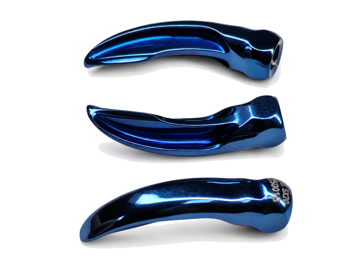Three contoured blue titanium alloy CNC machined medical components on a pure white background