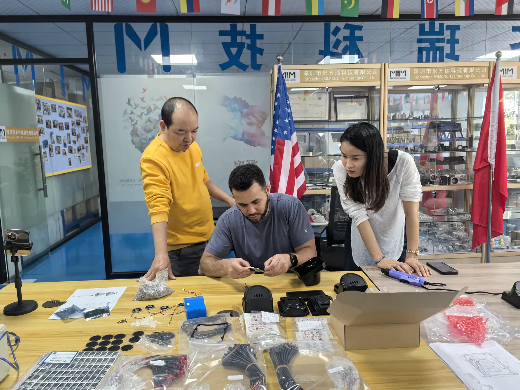 US customer reviewing finished injection molded products with the MIM Machining team