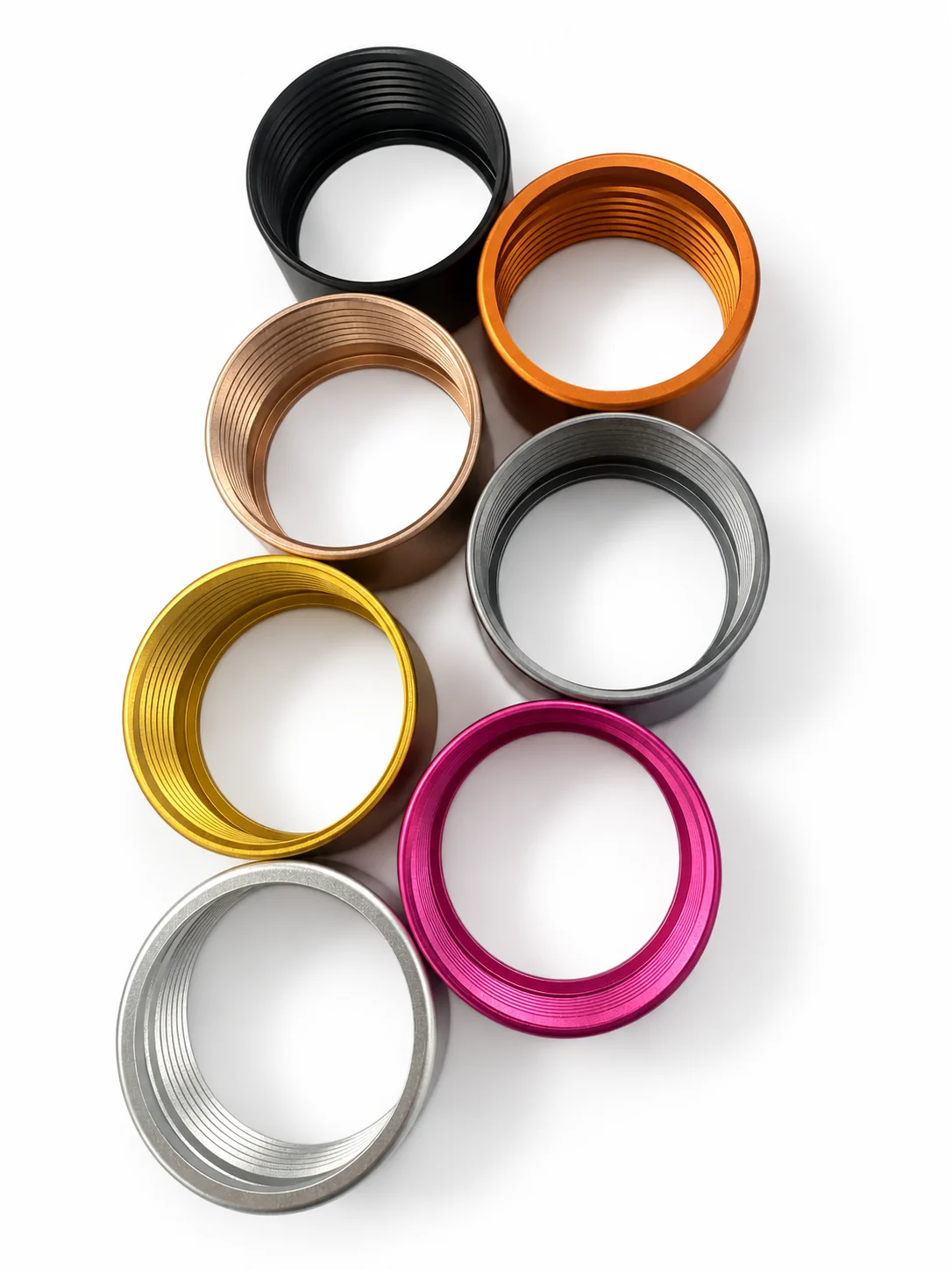 Threaded aluminum sample rings showing black, orange, bronze, gray, gold, pink and clear anodized finishes on a white background